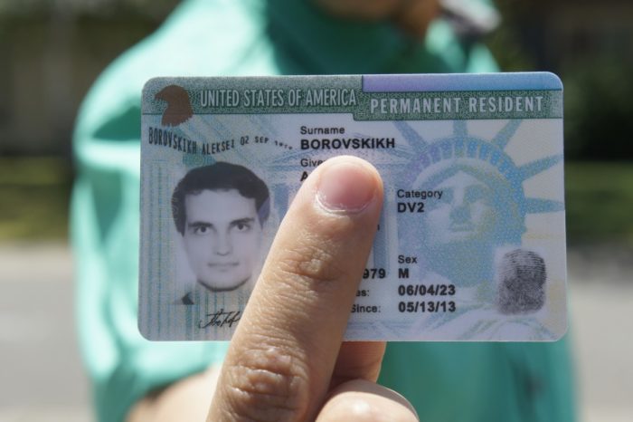 Человек держит Green Card
